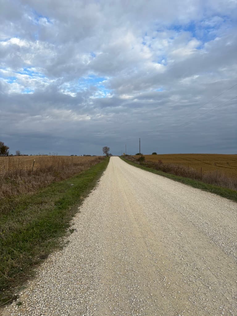 Open gravel road under cloudy sky